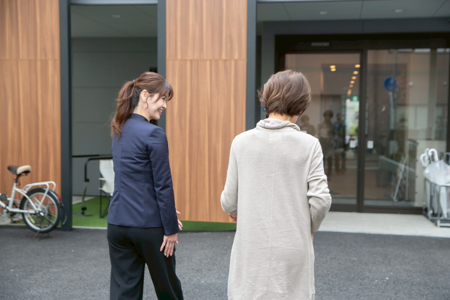 施設の入口で相談員が来訪した方を建物内へ案内している場面
